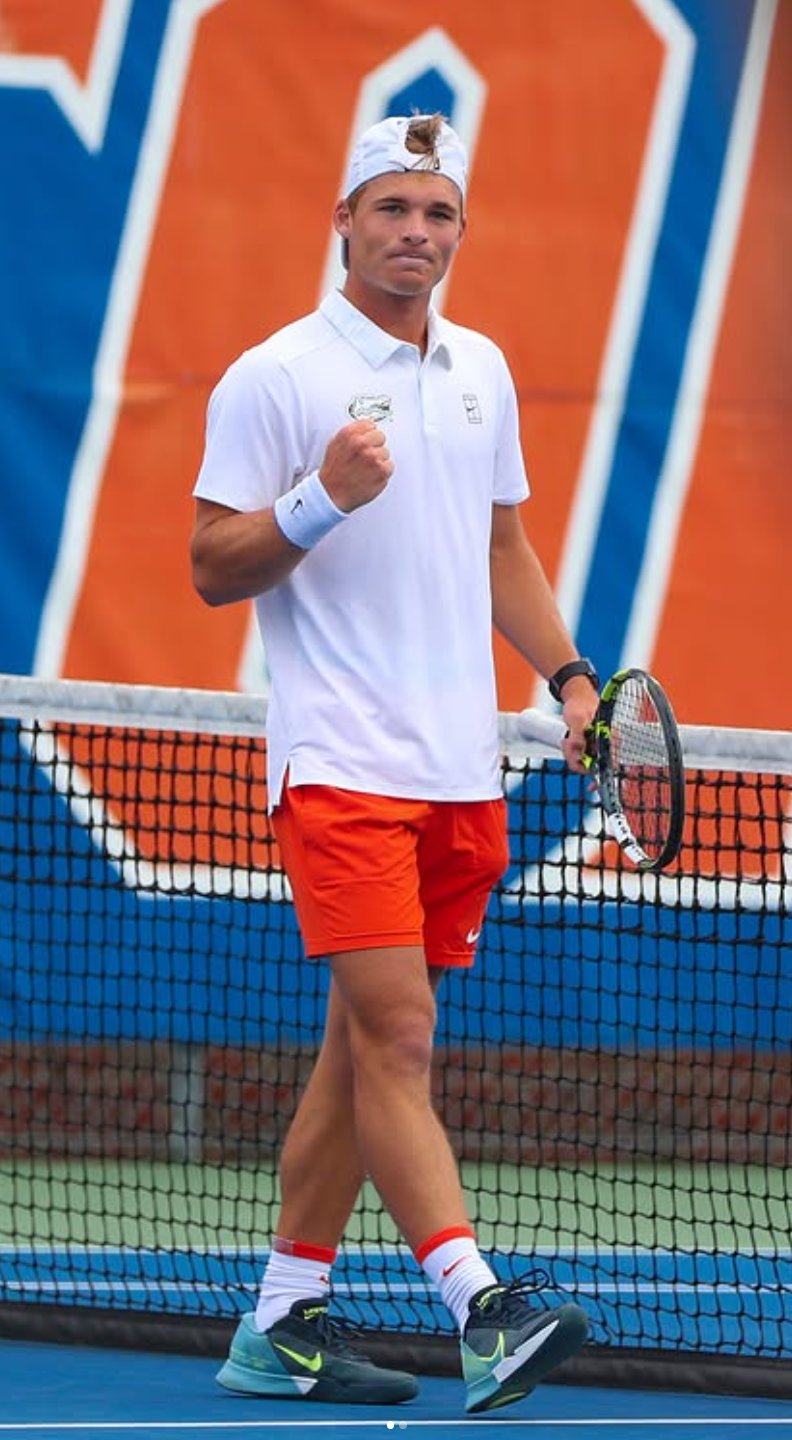 Kevin Edengren fist pump celebration in white Gators polo with orange shorts